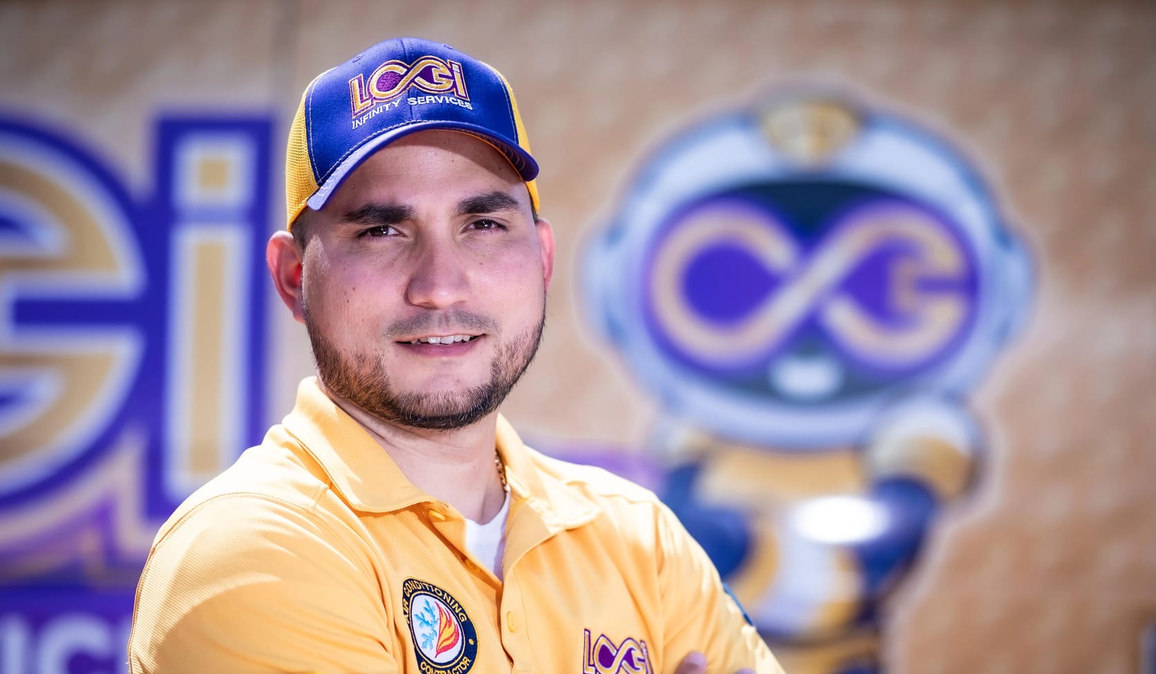 A LOGI Infinity Services technician, arms crossed, in front of the company logo